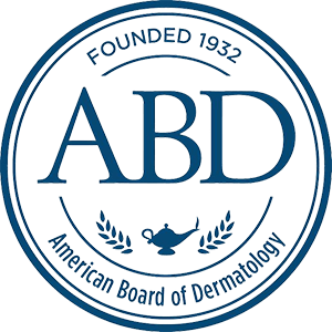 A circular blue and white seal displaying "ABD" prominently in the center. "FOUNDED 1932" is written at the top and "American Board of Dermatology" at the bottom, with two laurel branches and a lamp symbol between the words.